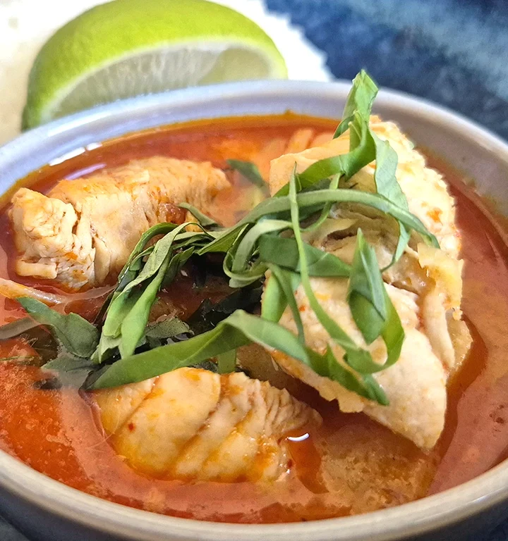 Thai Red Curry with Chicken and Pineapple, served with steamed jasmine rice and a wedge of lime.